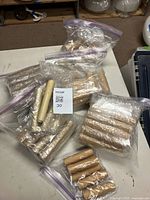 Multiple batches of beeswax candle covers sealed in clear plastic bags on a table