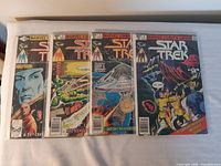 Photo showing all four comic books with colorful illustrated covers.