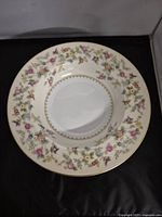 Close-up of the floral pattern and gold scalloped edge of one Noritake rimmed soup bowl.