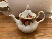 Small teapot with floral Old Country Roses pattern and gold trim, shown assembled with lid on.