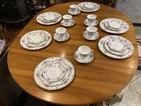 Overview of all six 5-piece place settings arranged on table showing complete set with plates, cups, and saucers