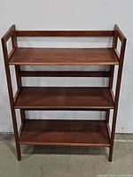 Front view of the three-shelf wooden bookshelf showing its open frame and shelving.