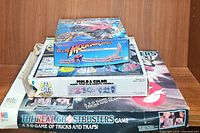 Stack of three boxed items including Mountain Climber kit on top, Gobots Mold & Color kit in middle, The Real Ghostbusters game at bottom.