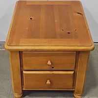 Top and front view of the pine nightstand showing two drawers and natural wood grain with knots.