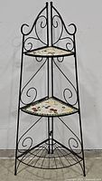 Full view of the black iron 3-tier corner plant stand showing overall structure and mosaic shelves.