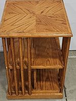 Front and side view of the mission style revolving bookcase showing the shelves and vertical slats.