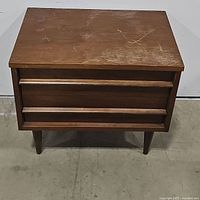 Front view of nightstand showing overall shape, drawers, and leg style