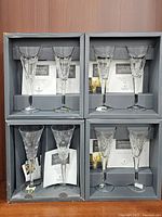 Four boxes each containing a pair of crystal toasting flutes from Waterford Millennium Collection with certificates inside the packaging.