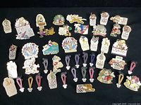 Full spread showing over 40 Disney Olympic trading pins with most pins laid out by type and color on black background.