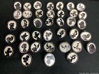 Overview of 38 Disney silhouette enamel pins arranged on black background