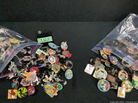 Two resealable baggies of assorted Disney enamel pins on black background