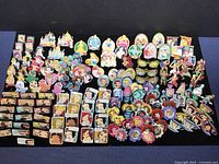 Full overview of all enamel pins arranged on black display board