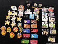 Photo showing entire assortment of 47 Disney trading pins with a range of characters and themed designs.