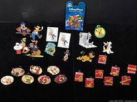 Full display of all 28 Disney trading pins featuring Goofy and Pluto, some limited editions and duplicates, with backing cards and day-of-the-week themed pins.
