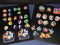 Pins mounted on black boards showing horoscope signs and character festival pins, some large limited edition ones.