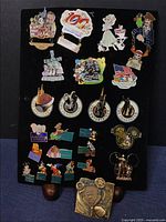 Display board with 24 colorful Disney enamel collectible pins arranged in rows