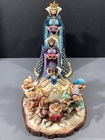 Jim Shore Heartwood Creek figurine featuring Snow White surrounded by all Seven Dwarfs with the Evil Queen and Old Hag behind.