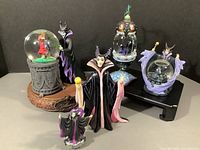 Overview of all five items: three snow globes, one porcelain figurine and one resin ornament