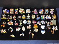 Full view of all 48 enamel pins on black felt background