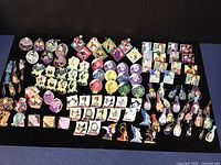 Multiple rows of Disney villain enamel pins laid out on a flat surface