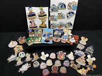 Multiple Disney World event and character trading pins laid out on a black background