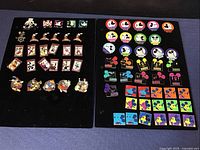 Two black display boards showing the full assortment of 69 Disney enamel pins.