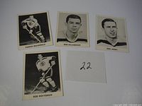 Four hockey cards featuring players Parker MacDonald, Bob Dillabough, Don Awrey, and Bob Woytowich shown laid out flat on a white surface.