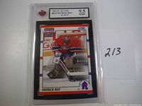 Front image of the 1990-91 Score hockey card showing Patrick Roy in Canadiens goalie gear, graded 9.5 by NGM in protective slab.