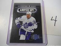 Front of 2021-22 Auston Matthews Amped UP Metal hockey card in clear sleeve showing player image, name, and team.