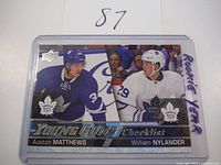 Front view of the 2016-17 Young Guns Rookie Card Checklist featuring Auston Matthews (blue jersey) and William Nylander (white jersey) with Toronto Maple Leafs logos, encased in plastic.