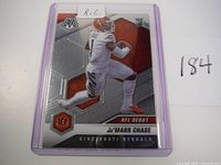 Front view of the Ja'Marr Chase 2021 NFL debut rookie card in protective sleeve showing player in action pose with team and card info.