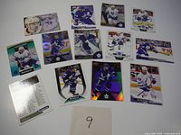 Overview photo showing 11 hockey cards laid out on white background including players Matthews, Marner, Nylander and others, plus checklist card.
