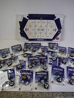 Full collection with all 24 mini hockey pucks sealed in original packaging placed on the hockey rink display stand.