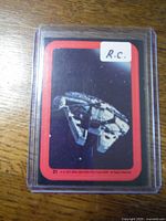 Image of a 1977 OPC Series 2 sticker depicting The Millennium Falcon encased in plastic protective sleeve.