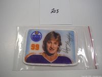 Front view of rectangular embroidered Wayne Gretzky Oilers crest patch in sealed plastic bag showing image, number 99, Oilers logo and printed signature