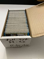 Box of tightly packed trading cards in original box labeled 'Full set 89-90 O-Pee-Chee Hockey'