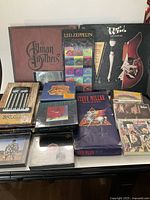 Overview of all CD box sets laid out on a table showing a variety of classic rock artists including The Allman Brothers, Led Zeppelin, The Who, Steve Miller Band, and The Beatles.