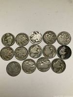 Top view of 14 Indian Head nickels showing obverse (front) sides with Native American profile and some wear marks.