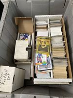 Gray plastic tote with inner cardboard boxes filled with loose and boxed cards