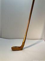 Full side view of wooden putter head and shaft