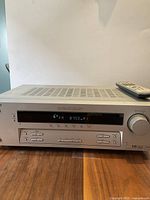 Sony STR-K750P receiver top vent and front panel with digital FM radio display, buttons, volume knob, and remote control on top.