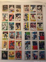 Photo overview showing 36 vintage hockey cards arranged in protective sleeves, featuring players from multiple NHL teams from various years with different card styles and colors.