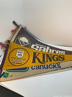 Image showing Los Angeles Kings, Buffalo Sabres and Vancouver Canucks vintage NHL pennants stacked.
