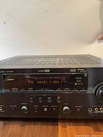 Front view of Yamaha HTR-6080 receiver showing power on with FM101.1 MHz frequency displayed.