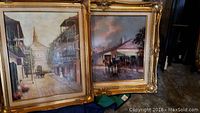 Photo showing both framed paintings standing against a wall, showing their overall size, frames, and scene details of New Orleans architecture and street views.