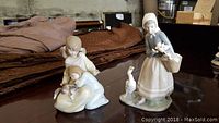 Two Lladro figurines on a table showing frontal and side views
