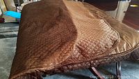 Brown velvet quilted bed quilt folded showing the plush texture and diamond stitch pattern.