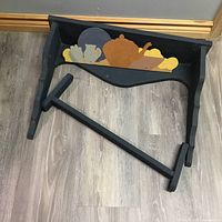 Wooden quilt rack painted black with tole painted tea set motif. The rack is disassembled.