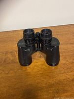 Full frontal view of black Getters Inc Sirius 7x35 binoculars with textured grip and center hinge.