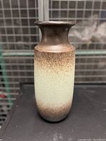 Front and side view of tall ceramic vase with textured gradient glaze from dark brown to cream.
